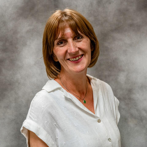 A woman in front of a patterned background