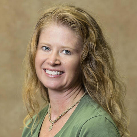 A woman in front of a brown background